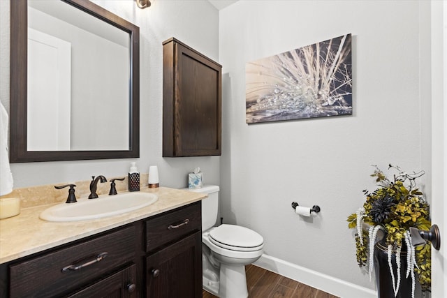 bathroom with vanity, toilet, and hardwood / wood-style floors