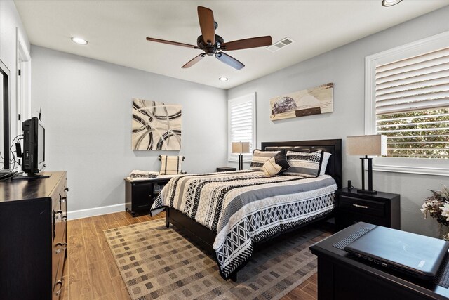 full bathroom with hardwood / wood-style flooring, shower / bath combo, vanity, and toilet