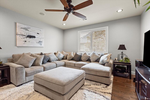 living room featuring ceiling fan and dark hardwood / wood-style flooring