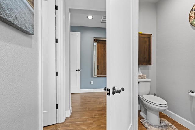 bathroom featuring wood-type flooring and toilet