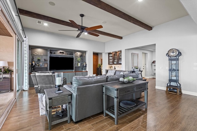 living room featuring dark wood-type flooring, indoor bar, beam ceiling, and ceiling fan