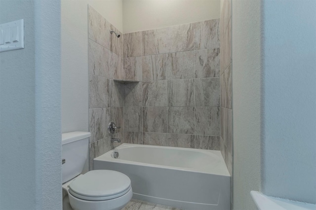 bathroom with toilet and tiled shower / bath combo