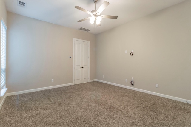 spare room with ceiling fan and carpet