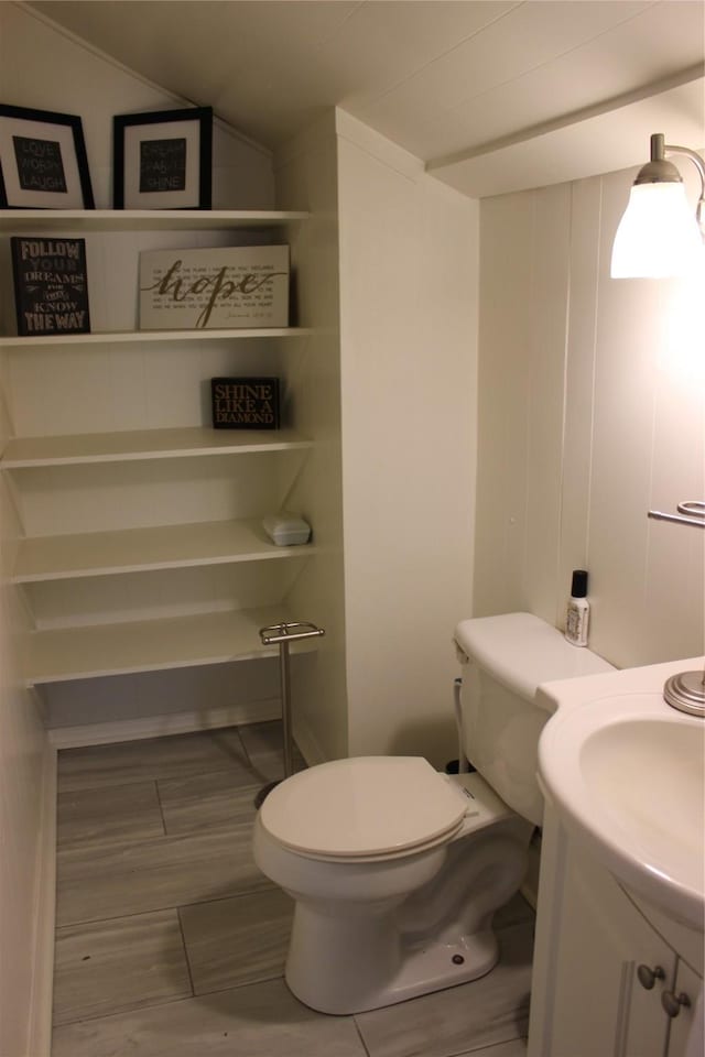 bathroom with vanity, toilet, and vaulted ceiling