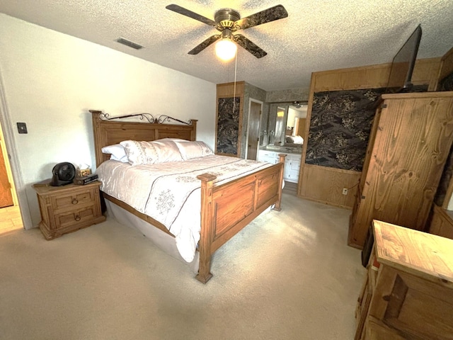 bedroom featuring ceiling fan, light colored carpet, and a textured ceiling