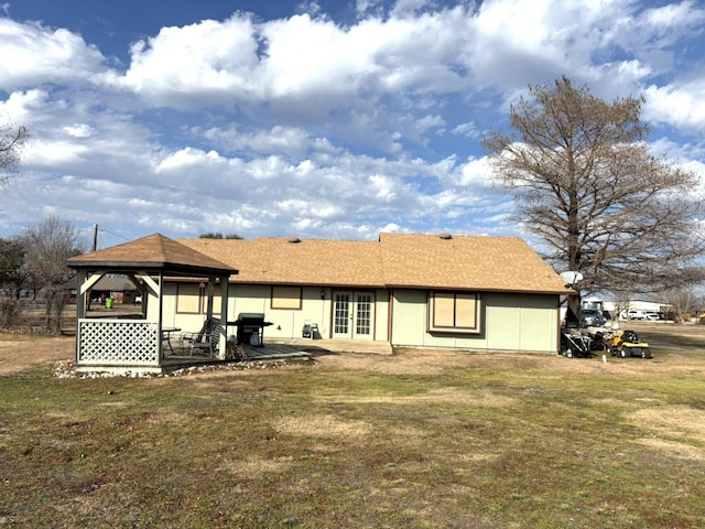 rear view of house featuring a gazebo and a lawn