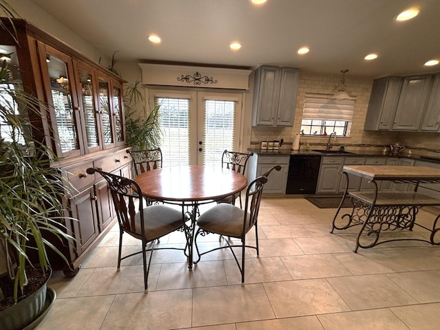 tiled dining space featuring sink and french doors