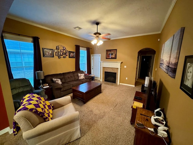 living room featuring ceiling fan, ornamental molding, carpet flooring, and plenty of natural light