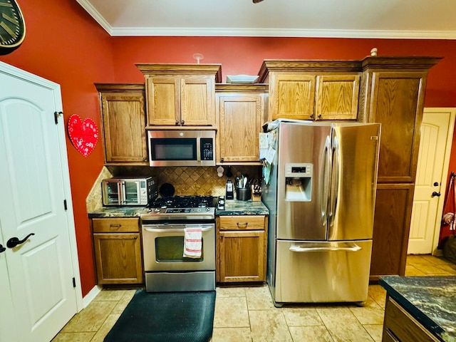 kitchen featuring stainless steel appliances, crown molding, backsplash, and dark stone counters