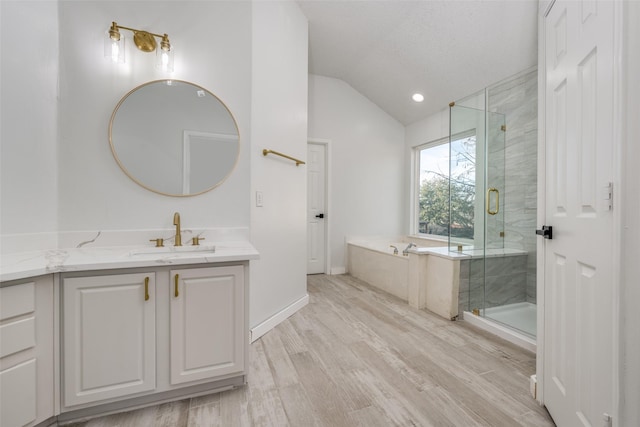 bathroom featuring separate shower and tub, vaulted ceiling, a textured ceiling, vanity, and hardwood / wood-style flooring