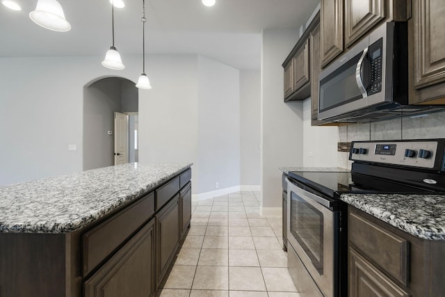 kitchen with stainless steel appliances, arched walkways, and dark brown cabinetry