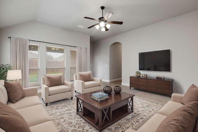 living room with light tile patterned flooring, a ceiling fan, visible vents, vaulted ceiling, and arched walkways