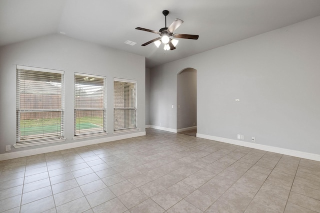 tiled empty room with ceiling fan and vaulted ceiling