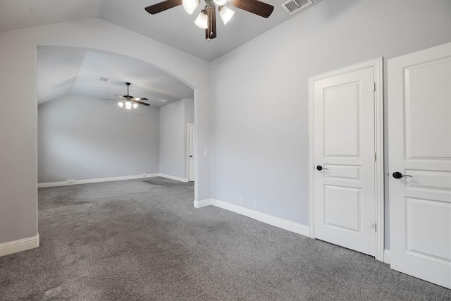 carpeted empty room featuring baseboards, visible vents, ceiling fan, and vaulted ceiling