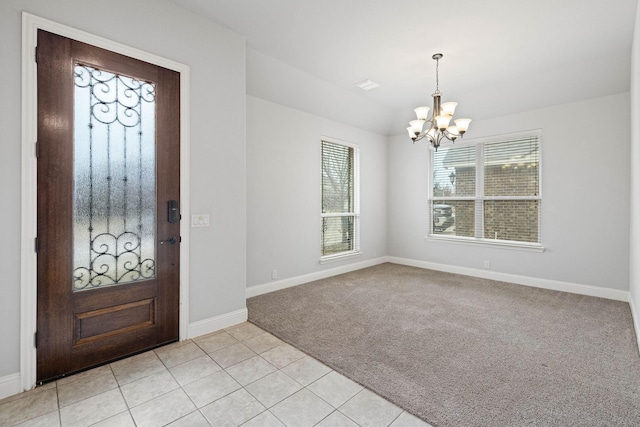 foyer entrance with a chandelier and light carpet