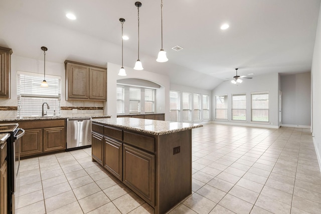 kitchen with light tile patterned floors, vaulted ceiling, dishwasher, a center island, and a ceiling fan