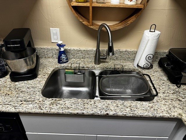 details featuring light stone counters and sink