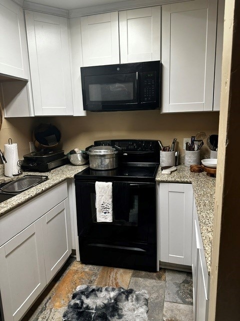 kitchen featuring white cabinetry, light stone countertops, sink, and black appliances