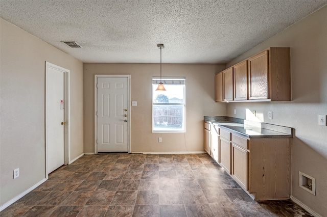 kitchen featuring hanging light fixtures and a textured ceiling