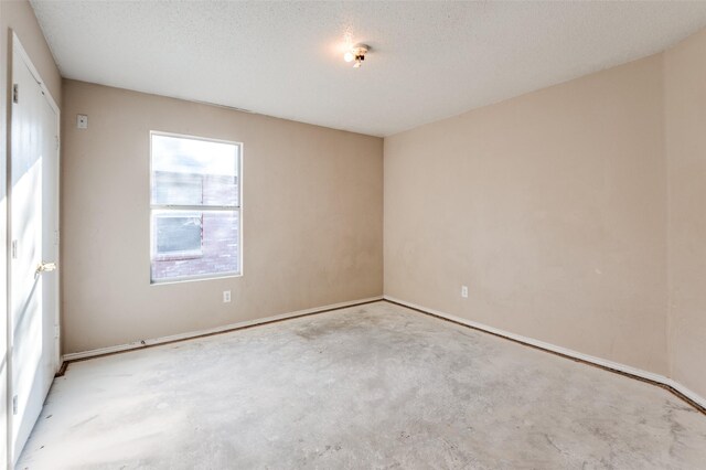 unfurnished room with concrete flooring and a textured ceiling