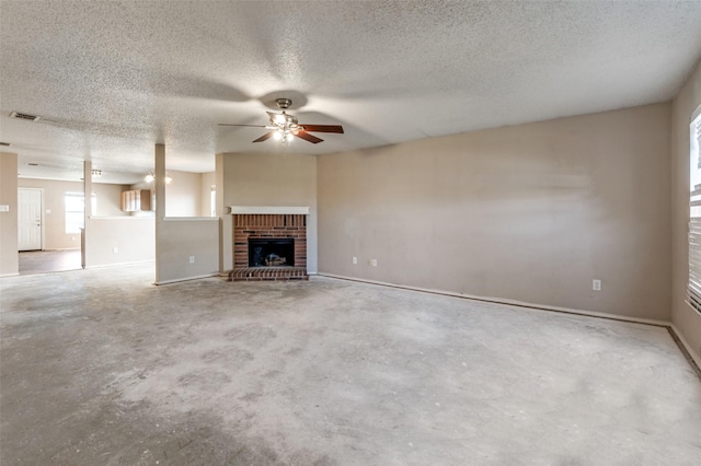 unfurnished living room with ceiling fan, a fireplace, concrete flooring, and a textured ceiling