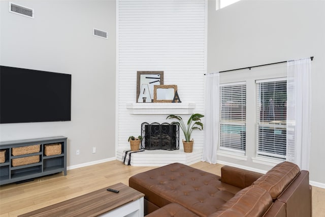 living room featuring hardwood / wood-style flooring and a brick fireplace