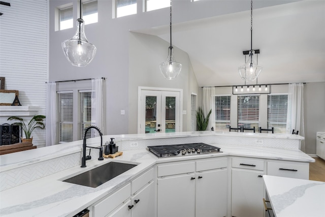 kitchen featuring sink, pendant lighting, white cabinets, and stainless steel gas cooktop