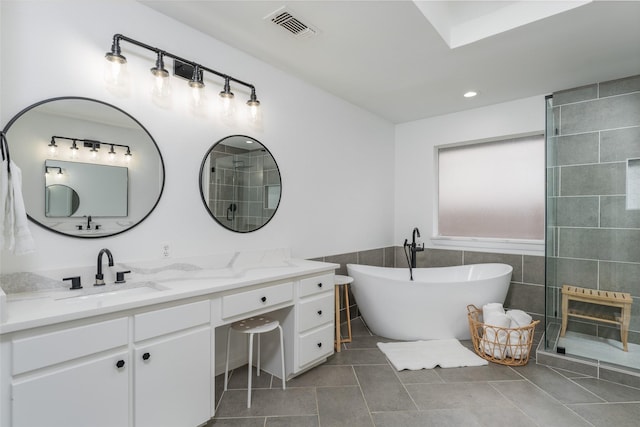 bathroom featuring tile patterned flooring, vanity, tile walls, and a bathtub