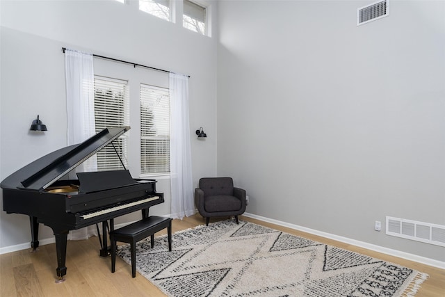 misc room with hardwood / wood-style floors and a high ceiling