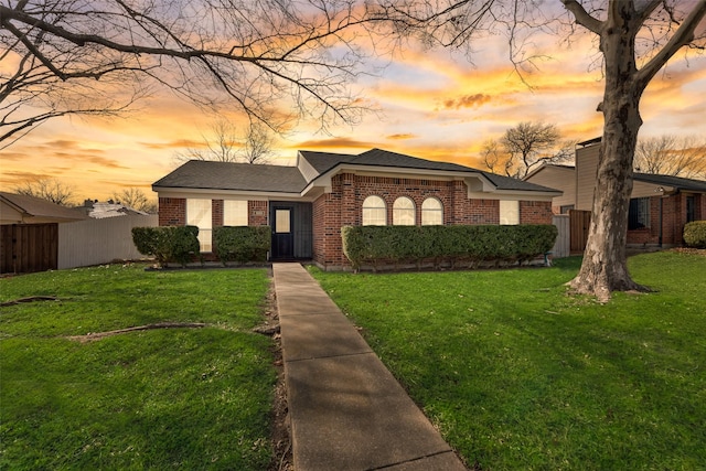 ranch-style home with a lawn