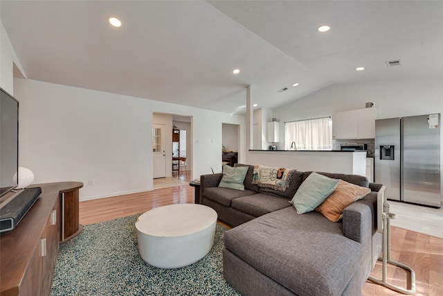 living room with vaulted ceiling and light hardwood / wood-style floors