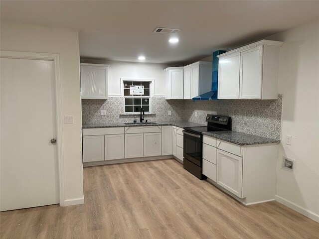 kitchen with white cabinetry, black / electric stove, wall chimney range hood, and sink