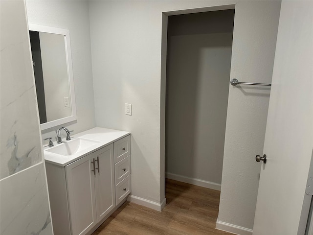 bathroom featuring vanity, wood finished floors, and baseboards