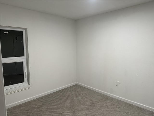 carpeted spare room with baseboards