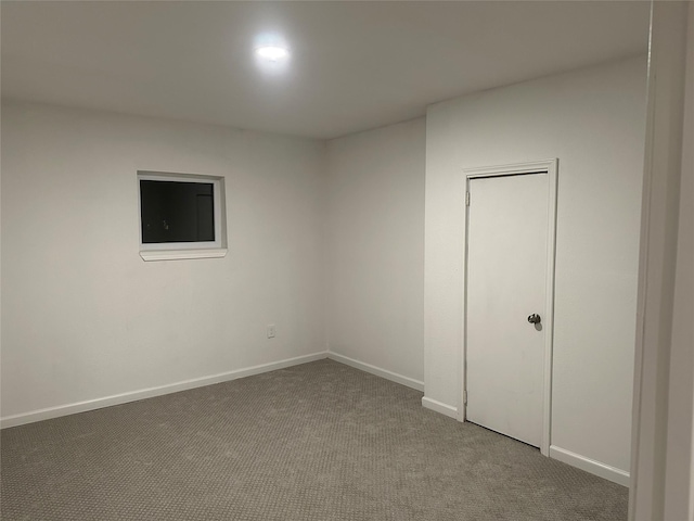 carpeted spare room featuring baseboards