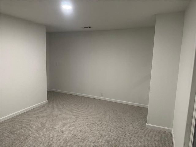 empty room featuring visible vents, baseboards, and carpet