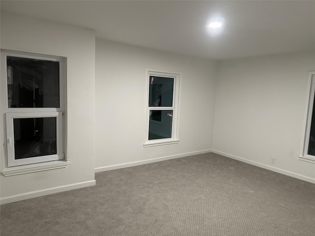 carpeted empty room with baseboards