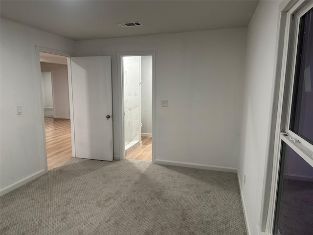 carpeted spare room with baseboards and visible vents