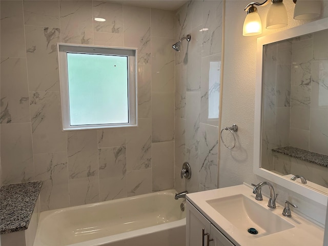 bathroom with vanity, shower / bath combination, and a textured wall