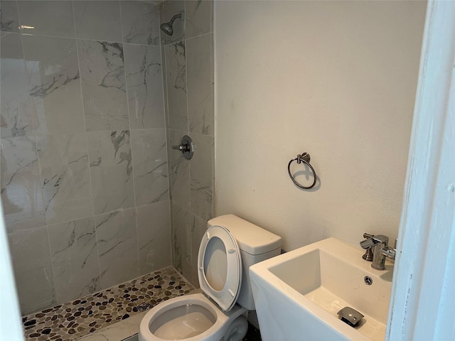 full bathroom featuring toilet, a stall shower, and a sink