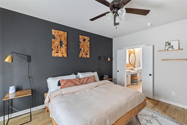 bedroom featuring ceiling fan, ensuite bathroom, and light wood-type flooring