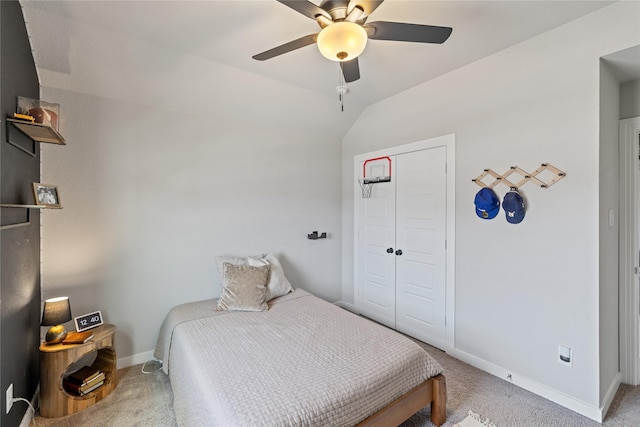 carpeted bedroom featuring ceiling fan, lofted ceiling, and a closet