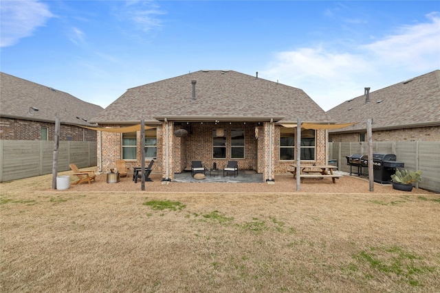 back of property with a yard and a patio area