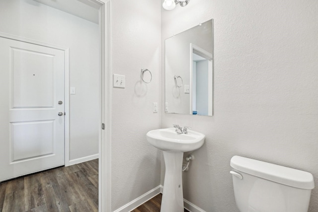 bathroom with hardwood / wood-style flooring and toilet