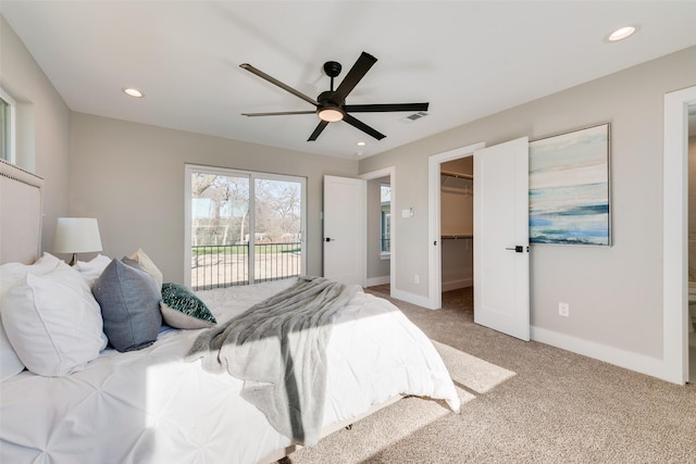 carpeted bedroom with ceiling fan, a spacious closet, and access to outside