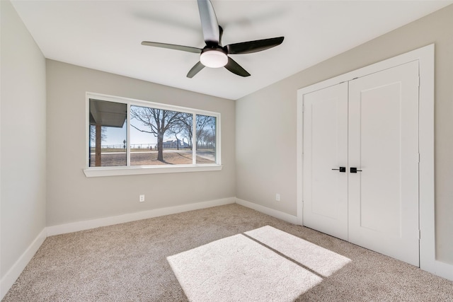 unfurnished bedroom with light colored carpet, ceiling fan, and a closet