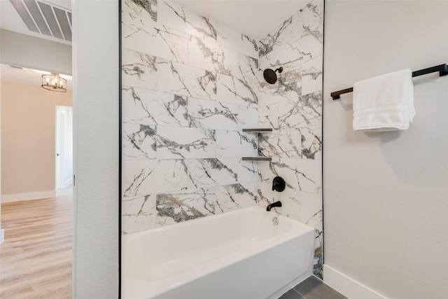 bathroom with tiled shower / bath and hardwood / wood-style floors