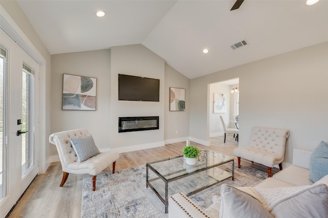 living room featuring light hardwood / wood-style floors and vaulted ceiling