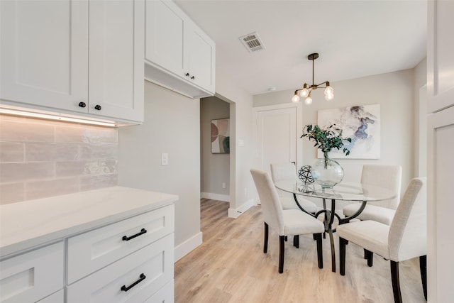 dining area with a chandelier and light wood-type flooring