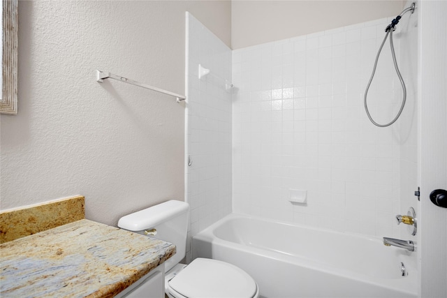 full bathroom featuring vanity, tiled shower / bath combo, and toilet